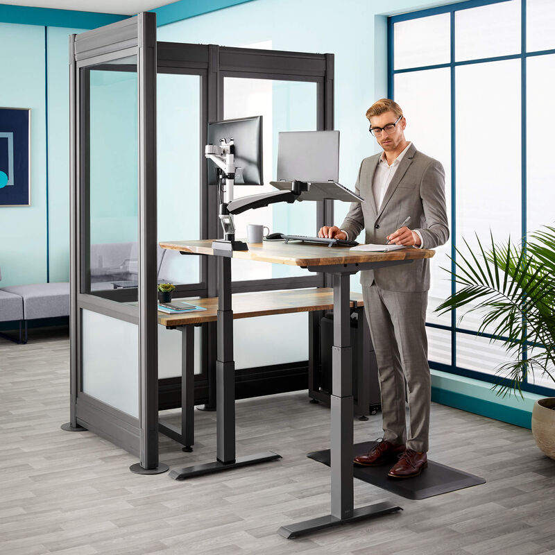professional works at electric standing desk in silver private office  image number null